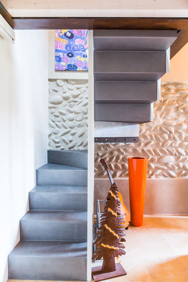 Photo of a mid-sized contemporary concrete u-shaped staircase in Milan with concrete risers.