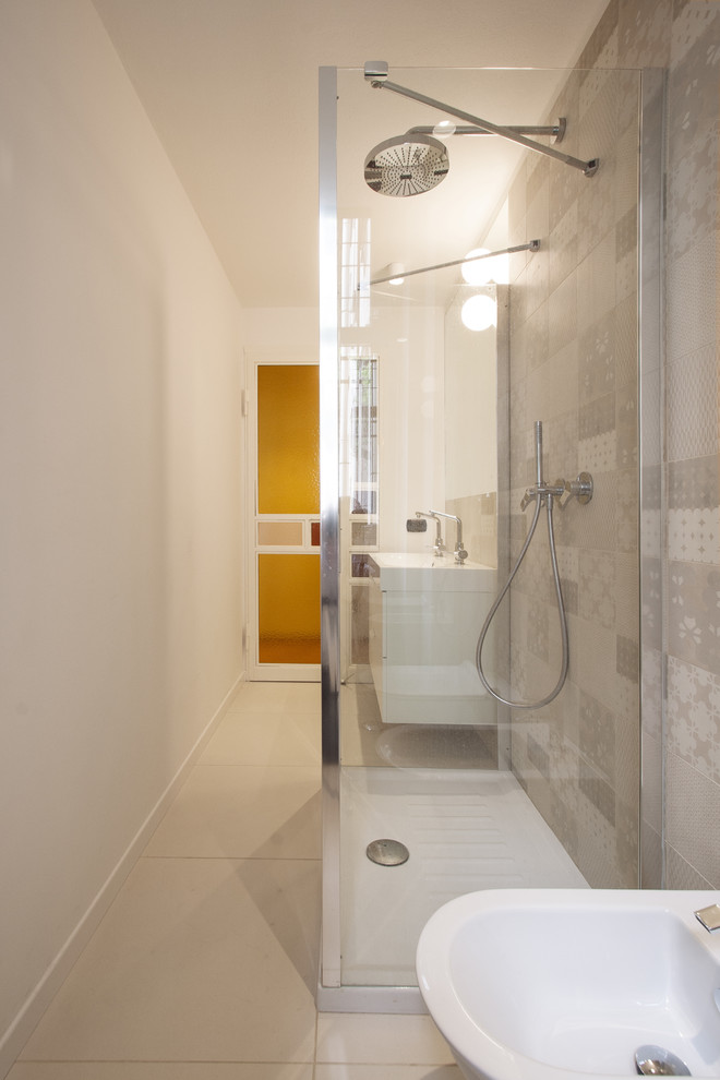 This is an example of a mid-sized midcentury 3/4 bathroom in Milan with flat-panel cabinets, white cabinets, a curbless shower, multi-coloured tile, porcelain tile, multi-coloured walls, porcelain floors, beige floor and a hinged shower door.