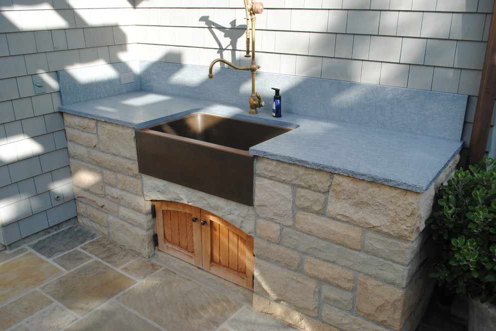 This is an example of a traditional backyard patio in Santa Barbara with an outdoor kitchen and natural stone pavers.