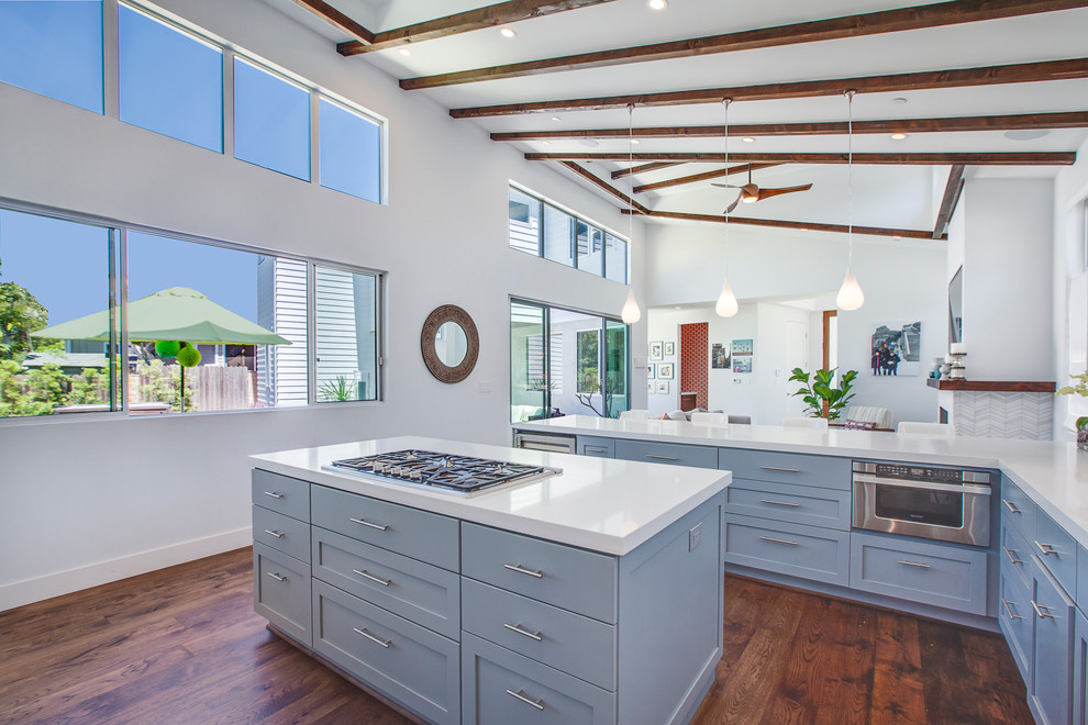 This is an example of a large contemporary u-shaped open plan kitchen in Los Angeles with shaker cabinets, blue cabinets, quartzite benchtops, with island, an undermount sink, stainless steel appliances and medium hardwood floors.