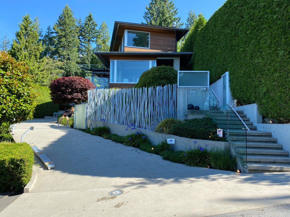 Photo of a mid-sized contemporary front yard formal garden in Other with with privacy feature and a metal fence.