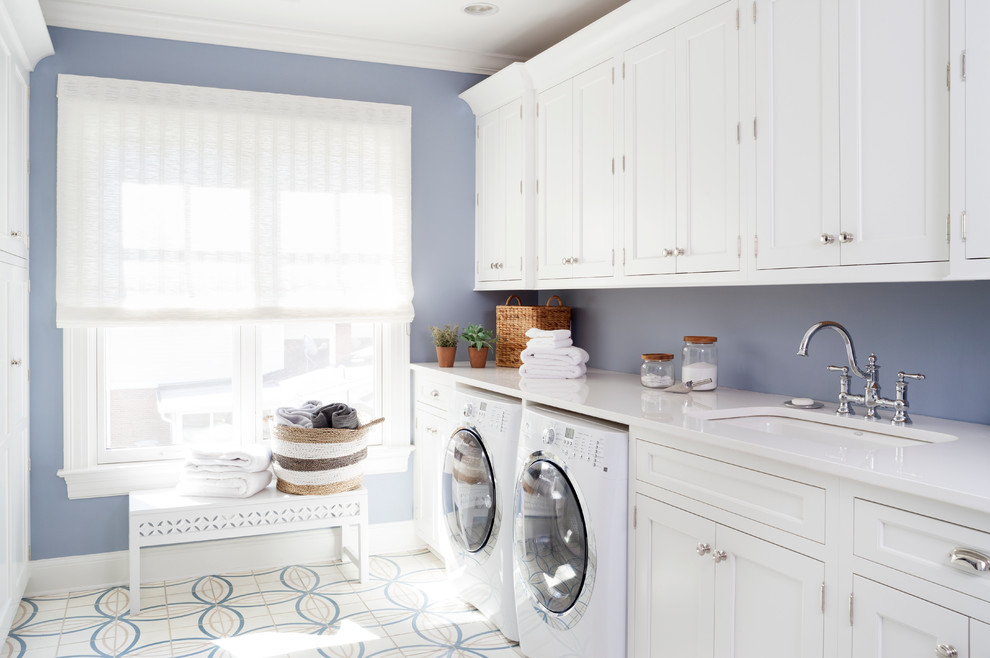 Photo of a large traditional galley dedicated laundry room in DC Metro with a single-bowl sink, recessed-panel cabinets, white cabinets, quartz benchtops, blue walls, ceramic floors and a side-by-side washer and dryer.