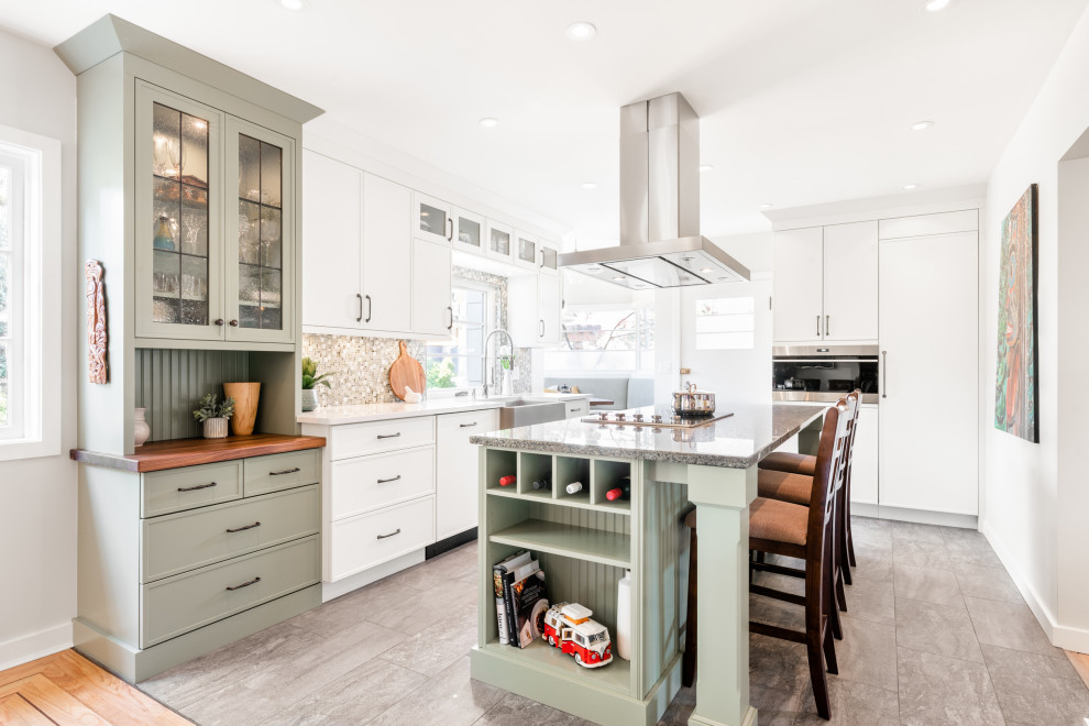 This is an example of a small country single-wall eat-in kitchen in Vancouver with a farmhouse sink, shaker cabinets, green cabinets, granite benchtops, multi-coloured splashback, mosaic tile splashback, stainless steel appliances, vinyl floors, with island, grey floor and multi-coloured benchtop.