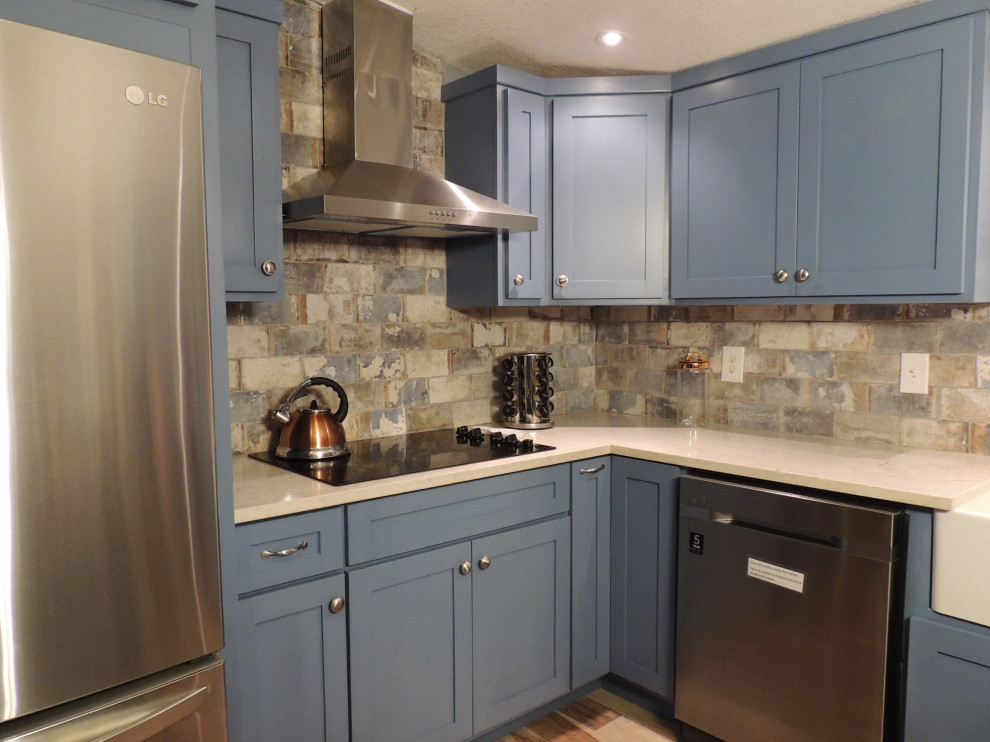 Foto på ett mellanstort lantligt flerfärgad kök, med en rustik diskho, skåp i shakerstil, blå skåp, träbänkskiva, grått stänkskydd, stänkskydd i stenkakel, rostfria vitvaror, mellanmörkt trägolv, en köksö och flerfärgat golv