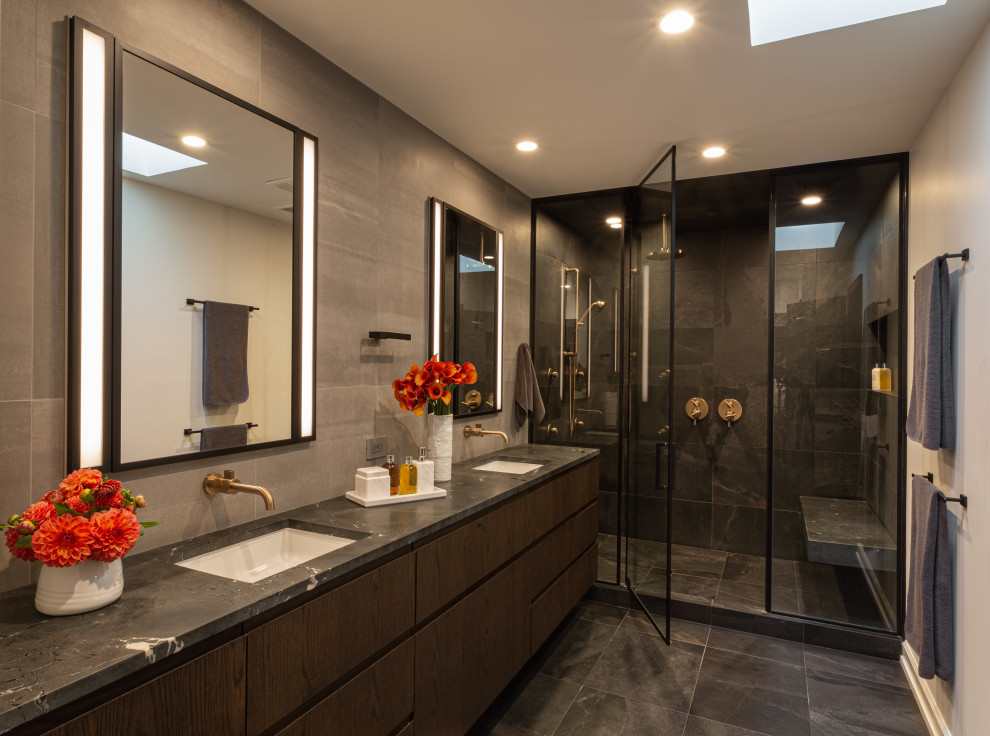 Photo of a large modern ensuite wet room bathroom in Chicago with flat-panel cabinets, brown cabinets, a bidet, grey tiles, porcelain tiles, white walls, porcelain flooring, a submerged sink, quartz worktops, black floors, a hinged door, black worktops, a shower bench, double sinks and a floating vanity unit.