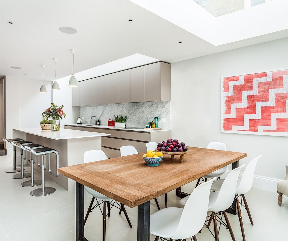 Photo of a contemporary kitchen/dining combo in London with white walls, white floor and porcelain floors.