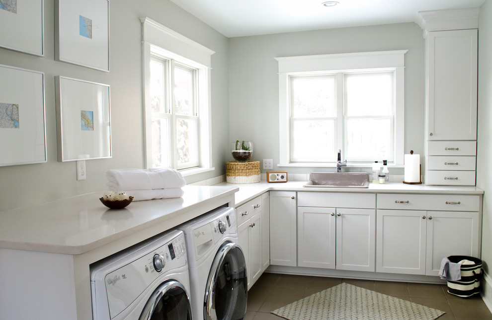 Example of a mid-sized classic l-shaped ceramic tile laundry room design with a drop-in sink, shaker cabinets, white cabinets, gray walls, a side-by-side washer/dryer and white countertops
