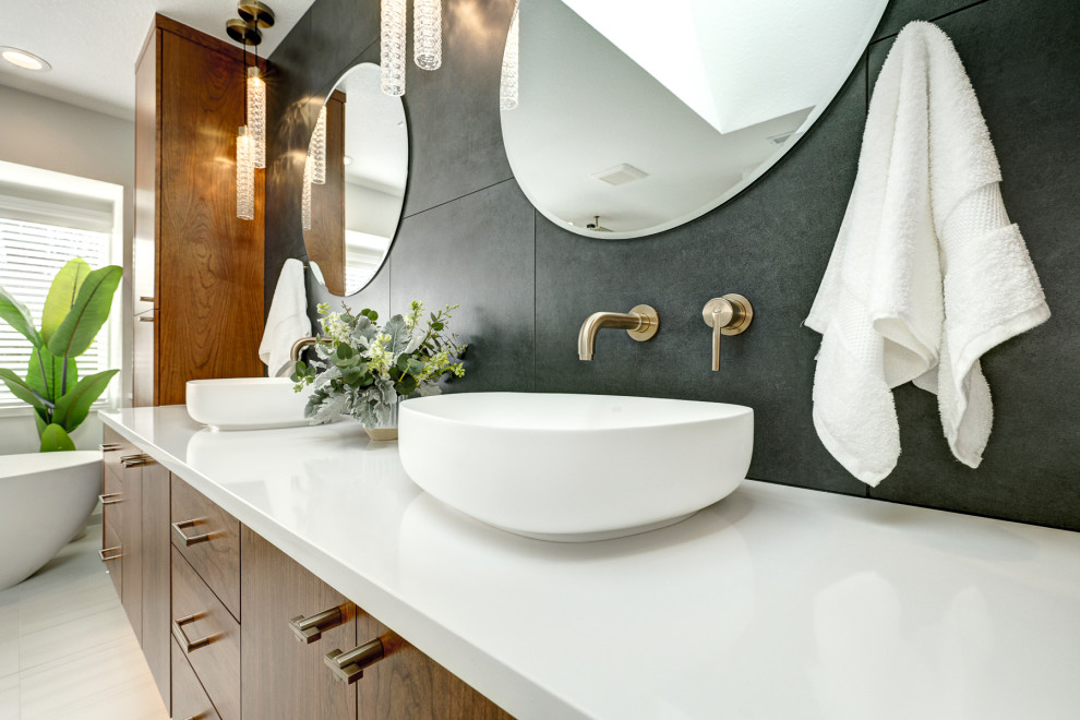 Foto på ett stort funkis vit en-suite badrum, med ett fristående badkar, svart kakel, ett fristående handfat och vitt golv