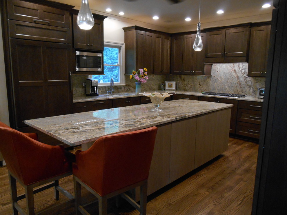 Inspiration for a mid-sized transitional l-shaped medium tone wood floor eat-in kitchen remodel in Birmingham with a single-bowl sink, flat-panel cabinets, medium tone wood cabinets, granite countertops, stone slab backsplash, paneled appliances, beige walls and an island