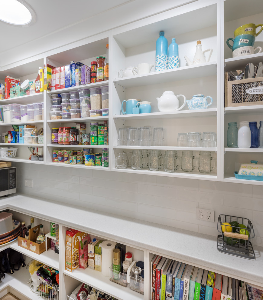 Design ideas for a transitional kitchen pantry in Perth with white cabinets, laminate benchtops, white splashback, subway tile splashback, open cabinets and grey benchtop.