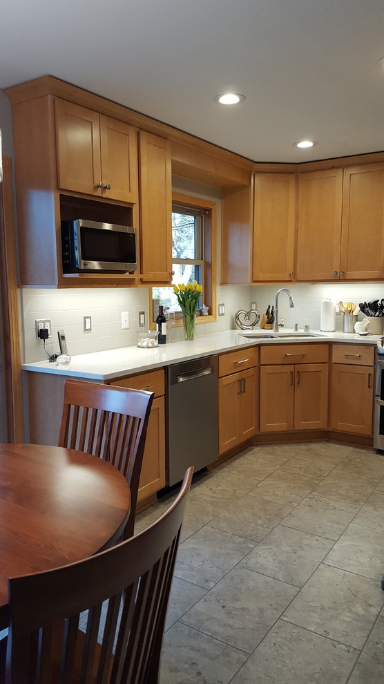 Eat-in kitchen - mid-sized transitional l-shaped ceramic tile eat-in kitchen idea with an undermount sink, shaker cabinets, light wood cabinets, quartz countertops, gray backsplash, subway tile backsplash, stainless steel appliances and no island