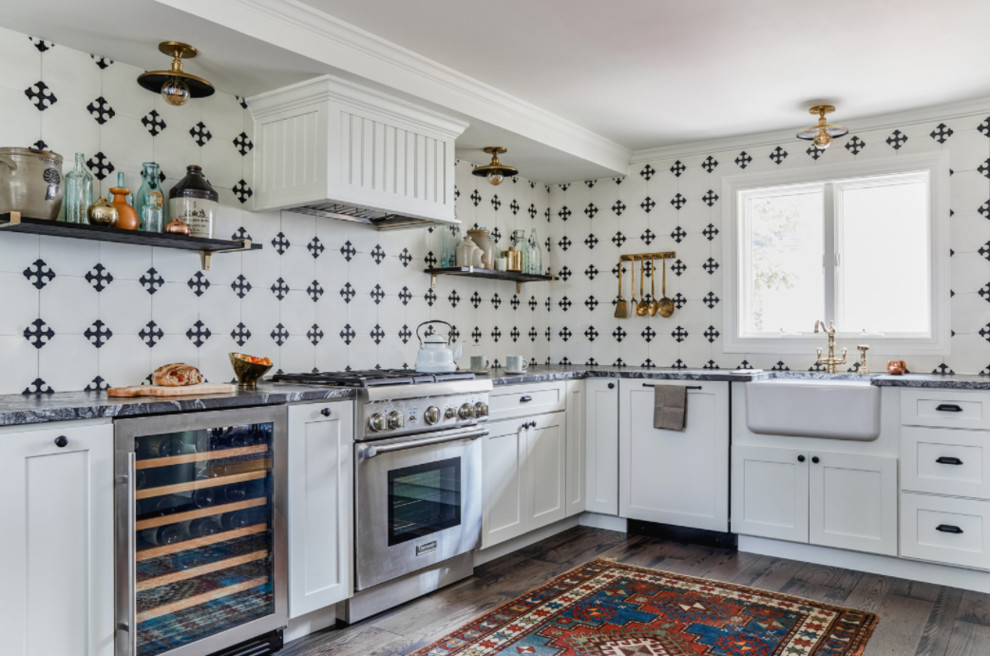 Inspiration for a mid-sized traditional l-shaped kitchen in Portland Maine with a farmhouse sink, shaker cabinets, white cabinets, white splashback, stainless steel appliances, no island, grey benchtop, dark hardwood floors and brown floor.