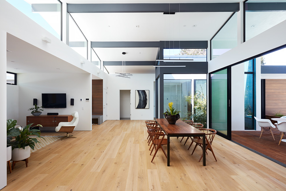 Los Altos New Residence - Klopf Architecture and Outer space Landscape Architects designed a new warm, modern, open, indoor-outdoor home in Los Altos, California. Inspired by mid-century modern homes but looking for something completely new and custom, the owners, a couple with two children, bought an older ranch style home with the intention of replacing it. 

Created on a grid, the house is designed to be at rest with differentiated spaces for activities; living, playing, cooking, dining and a piano space. The low-sloping gable roof over the great room brings a grand feeling to the space. The clerestory windows at the high sloping roof make the grand space light and airy. 
Upon entering the house, an open atrium entry in the middle of the house provides light and nature to the great room. The Heath tile wall at the back of the atrium blocks direct view of the rear yard from the entry door for privacy. 
The bedrooms, bathrooms, play room and the sitting room are under flat wing-like roofs that balance on either side of the low sloping gable roof of the main space. Large sliding glass panels and pocketing glass doors foster openness to the front and back yards. In the front there is a fenced-in play space connected to the play room, creating an indoor-outdoor play space that could change in use over the years. The play room can also be closed off from the great room with a large pocketing door. In the rear, everything opens up to a deck overlooking a pool where the family can come together outdoors.
Wood siding travels from exterior to interior, accentuating the indoor-outdoor nature of the house. Where the exterior siding doesn’t come inside, a palette of white oak floors, white walls, walnut cabinetry, and dark window frames ties all the spaces together to create a uniform feeling and flow throughout the house. The custom cabinetry matches the minimal joinery of the rest of the house, a trim-less, minimal appearance. Wood siding was mitered in the corners, including where siding meets the interior drywall. Wall materials were held up off the floor with a minimal reveal. This tight detailing gives a sense of cleanliness to the house. 
The garage door of the house is completely flush and of the same material as the garage wall, de-emphasizing the garage door and making the street presentation of the house kinder to the neighborhood.
The house is akin to a custom, modern-day Eichler home in many ways. Inspired by mid-century modern homes with today’s materials, approaches, standards, and technologies. The goals were to create an indoor-outdoor home that was energy-efficient, light and flexible for young children to grow. This 3,000 square foot, 3 bedroom, 2.5 bathroom new house is located in Los Altos in the heart of the Silicon Valley. 


Klopf Architecture Project Team: John Klopf, AIA, and Chuang-Ming Liu
 Landscape Architect: Outer space Landscape Architects
 Structural Engineer: ZFA Structural Engineers
 Staging: Da Lusso Design 
 Photography ©2018 Mariko Reed
 Location: Los Altos, CA 
Year completed: 2017
