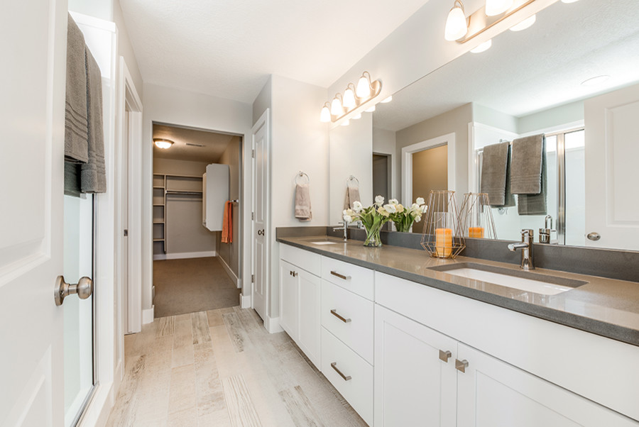 Design ideas for a mid-sized arts and crafts master bathroom in Salt Lake City with shaker cabinets, white cabinets, an alcove shower, grey walls, an undermount sink, engineered quartz benchtops, beige floor, a hinged shower door and light hardwood floors.