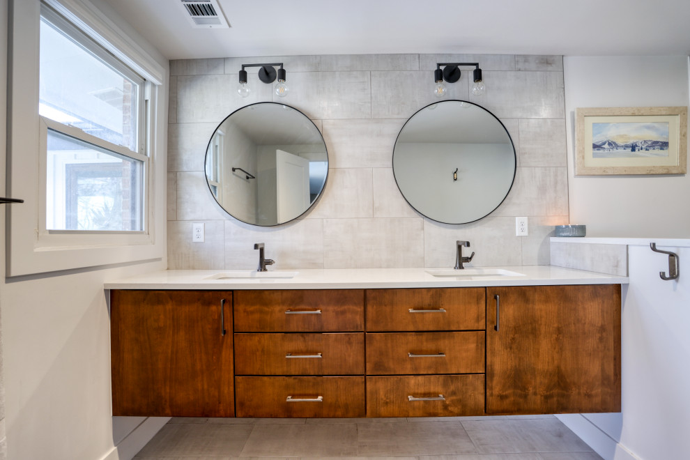 Large transitional l-shaped light wood floor and brown floor kitchen photo with a farmhouse sink, recessed-panel cabinets, white cabinets, quartz countertops, white backsplash, stainless steel appliances, an island and white countertops