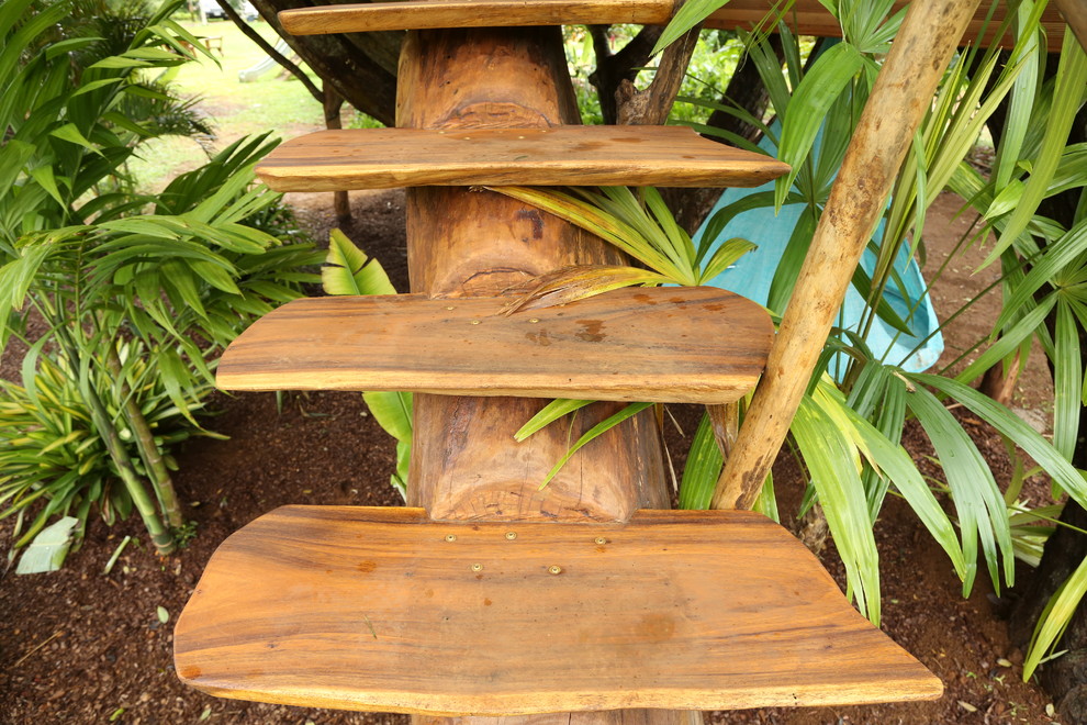 Photo of a small tropical wood straight staircase in Hawaii with open risers and wood railing.
