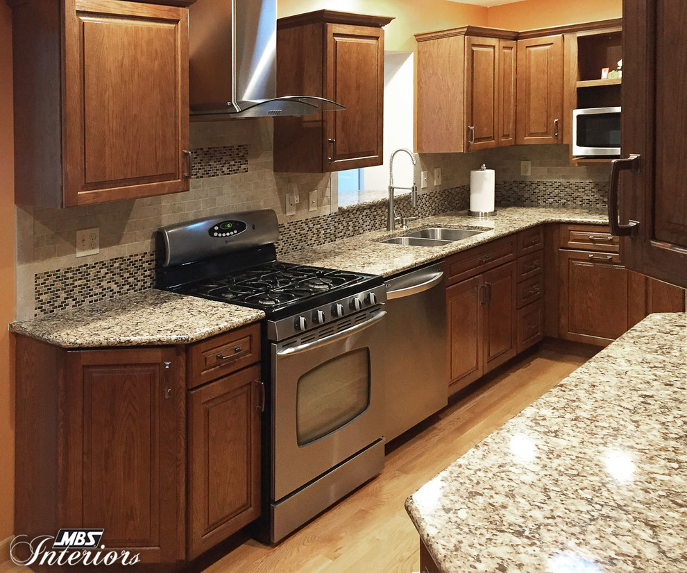 Small transitional light wood floor enclosed kitchen photo with an undermount sink, medium tone wood cabinets, quartz countertops, gray backsplash, stone tile backsplash, stainless steel appliances and no island