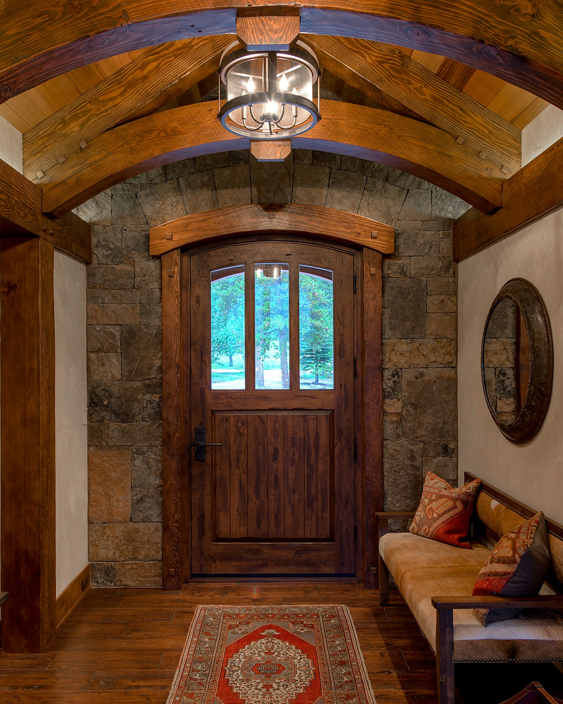 Mountain style dark wood floor and brown floor foyer photo in Denver with beige walls and a dark wood front door
