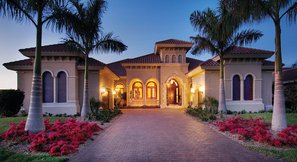 Inspiration for a large mediterranean one-storey stucco beige exterior in Miami.