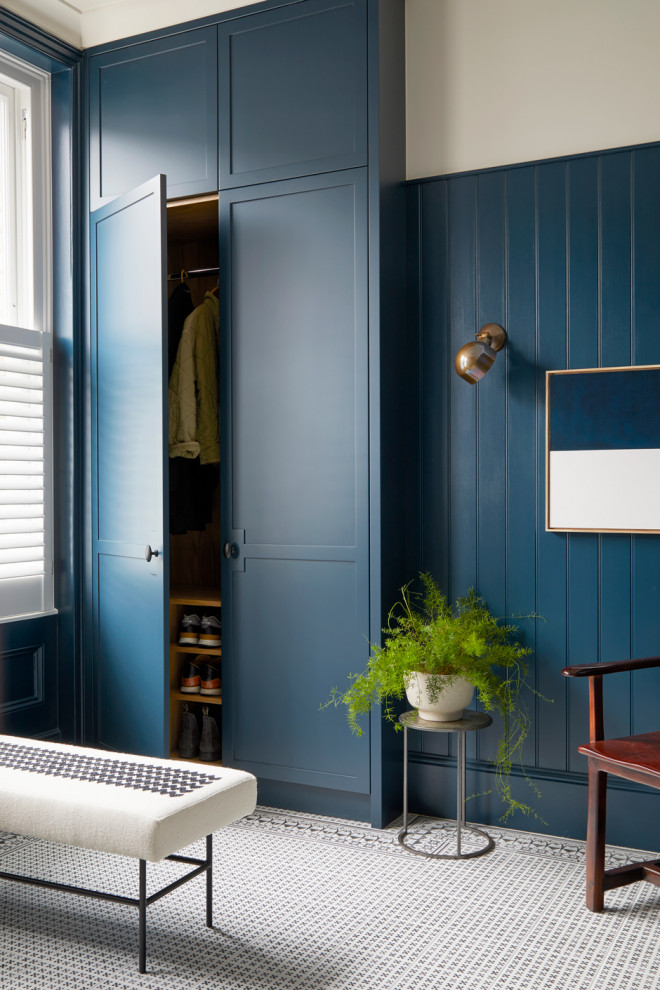 Aménagement d'une armoire encastrée contemporaine de taille moyenne et neutre avec tomettes au sol, un placard à porte shaker, des portes de placard bleues et un sol blanc.