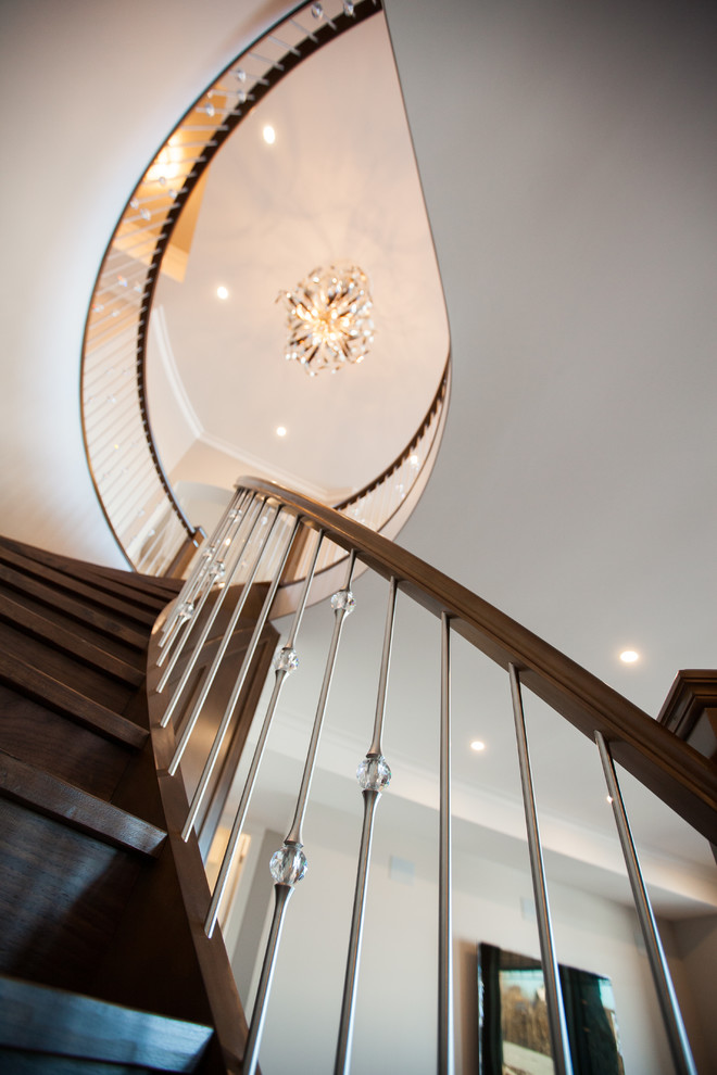 Photo of a large contemporary wood curved staircase in Edmonton with wood risers.
