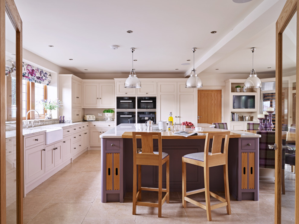 Expansive eat-in kitchen in Other with a farmhouse sink, beaded inset cabinets, purple cabinets, black appliances, with island, beige floor and white benchtop.