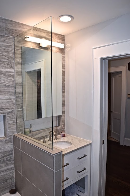 This is an example of a mid-sized transitional bathroom in Atlanta with flat-panel cabinets, yellow cabinets, an alcove tub, a shower/bathtub combo, beige tile, brown tile, porcelain tile, grey walls, porcelain floors, an undermount sink and marble benchtops.