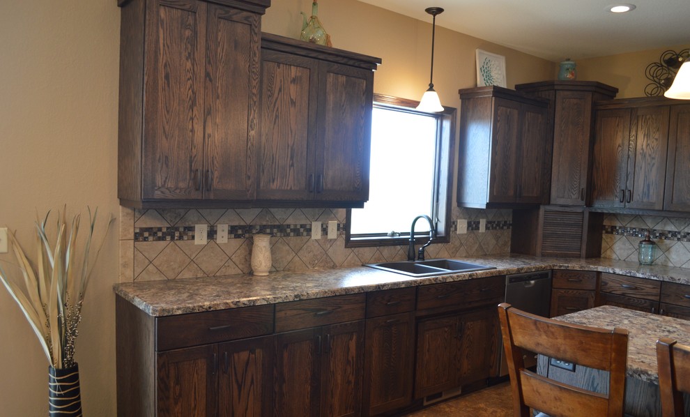 Mid-sized mountain style l-shaped laminate floor and beige floor eat-in kitchen photo with a drop-in sink, recessed-panel cabinets, dark wood cabinets, granite countertops, beige backsplash, stainless steel appliances, an island and ceramic backsplash