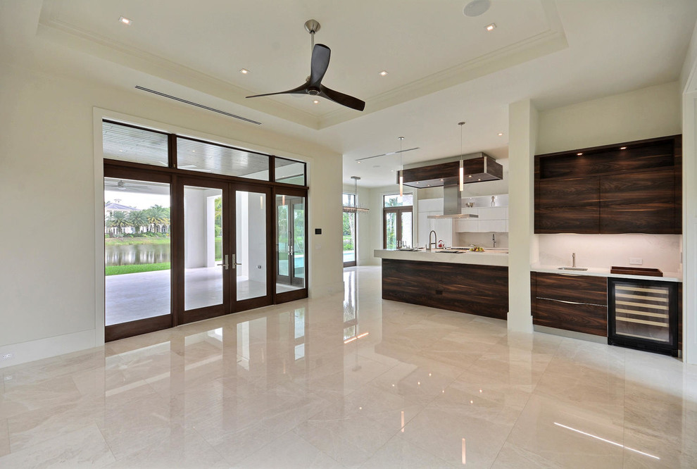 Large contemporary open concept family room in Miami with white walls, marble floors and a wall-mounted tv.