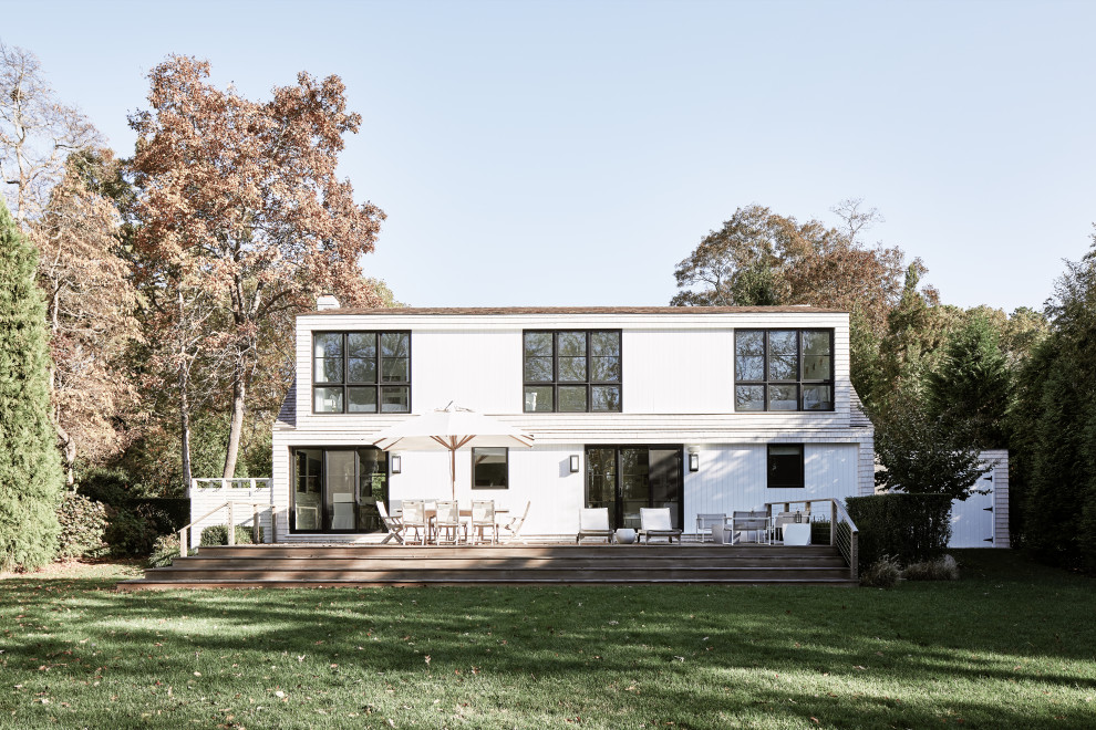Mittelgroßes, Zweistöckiges Klassisches Haus mit weißer Fassadenfarbe, Satteldach, Schindeldach, weißem Dach und Schindeln in New York