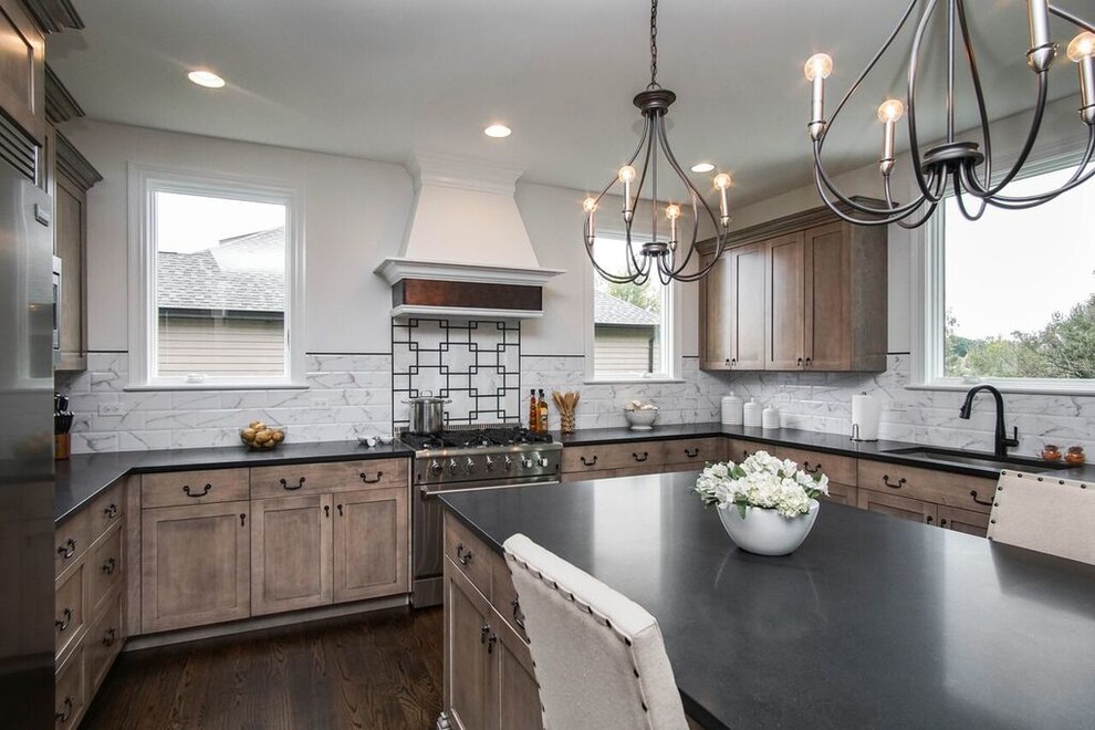 Example of a transitional u-shaped dark wood floor and black floor eat-in kitchen design in Chicago with an undermount sink, shaker cabinets, granite countertops, white backsplash, ceramic backsplash, stainless steel appliances, an island and black countertops