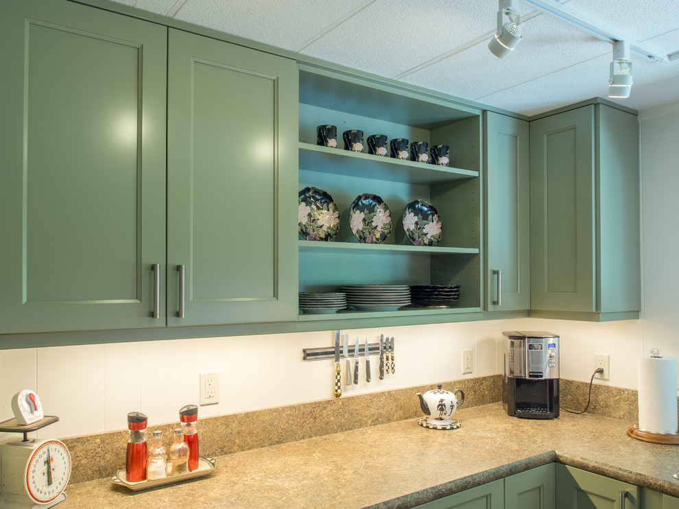Small transitional u-shaped vinyl floor and brown floor enclosed kitchen photo in Seattle with a drop-in sink, recessed-panel cabinets, green cabinets, laminate countertops, brown backsplash, stainless steel appliances, no island and brown countertops