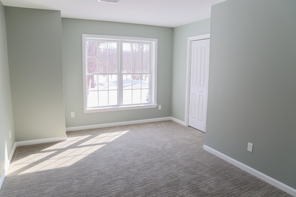 Photo of a traditional bedroom in Portland Maine with green walls and carpet.