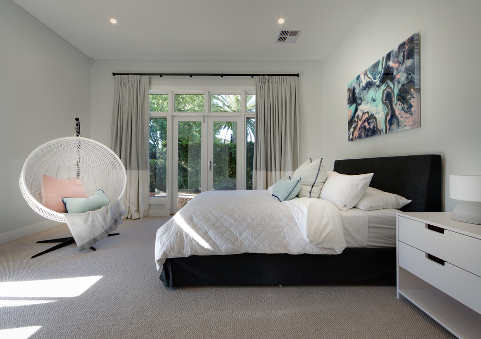 Contemporary bedroom in Melbourne with white walls and carpet.