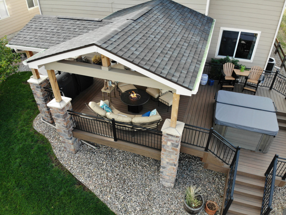Design ideas for a mid-sized transitional backyard and first floor deck in Denver with a fire feature, a roof extension and metal railing.