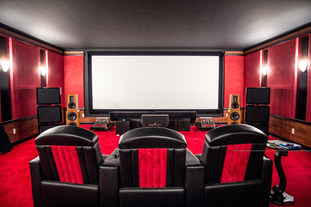 Inspiration for a large midcentury enclosed home theatre in Chicago with red walls, carpet, a projector screen and red floor.