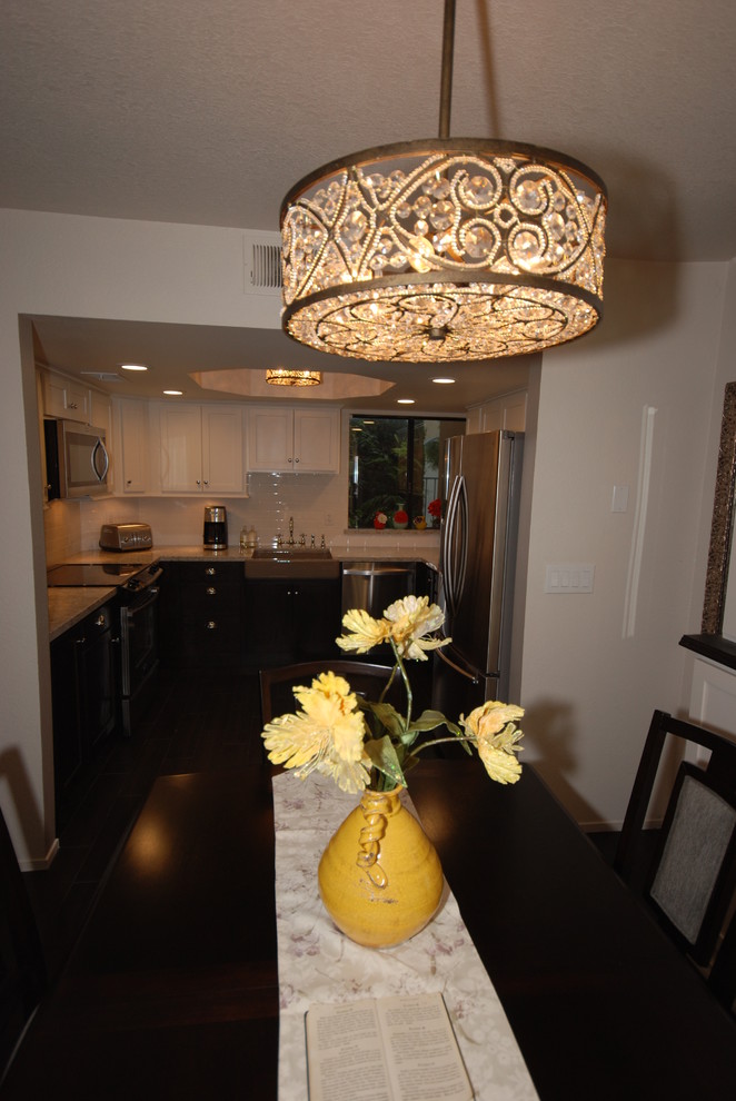 Eat-in kitchen - small transitional u-shaped porcelain tile eat-in kitchen idea with a farmhouse sink, shaker cabinets, white cabinets, quartz countertops, white backsplash, subway tile backsplash, stainless steel appliances and gray walls