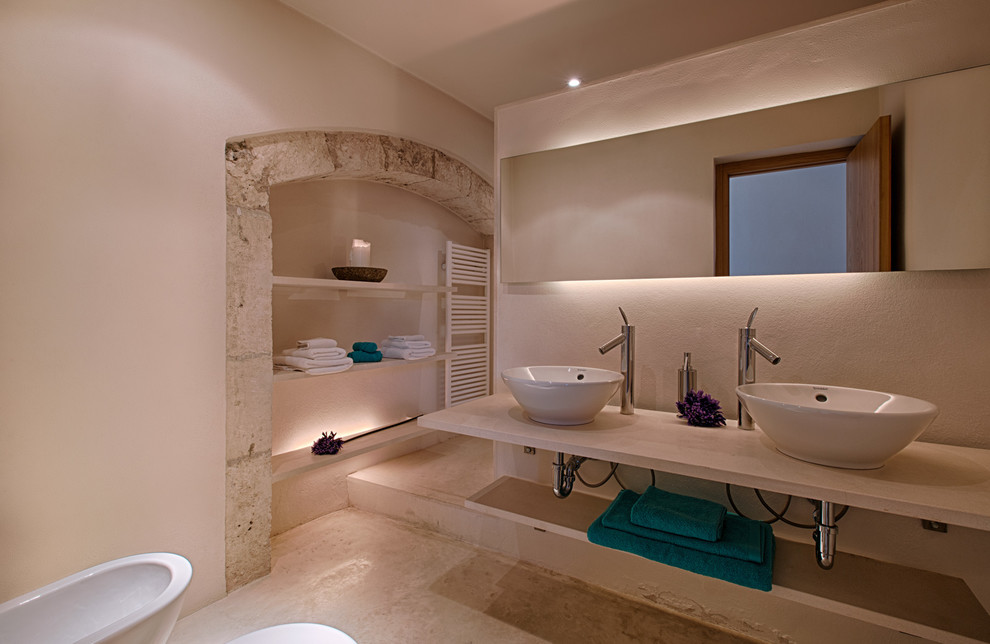 Photo of a mid-sized transitional powder room in Palma de Mallorca with open cabinets and a vessel sink.