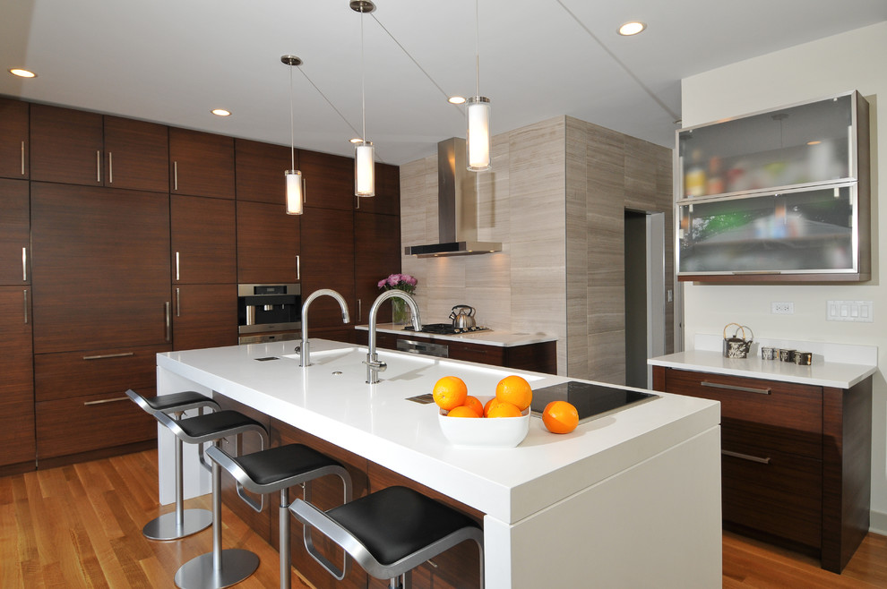 Inspiration for a mid-sized contemporary l-shaped open plan kitchen in Chicago with an integrated sink, flat-panel cabinets, dark wood cabinets, quartz benchtops, beige splashback, panelled appliances, with island, light hardwood floors and stone tile splashback.
