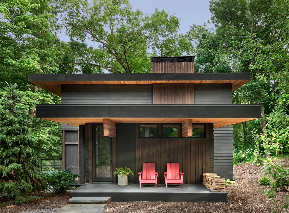 Inspiration for a mid-sized country three-storey black house exterior in Chicago with concrete fiberboard siding, a flat roof and a green roof.