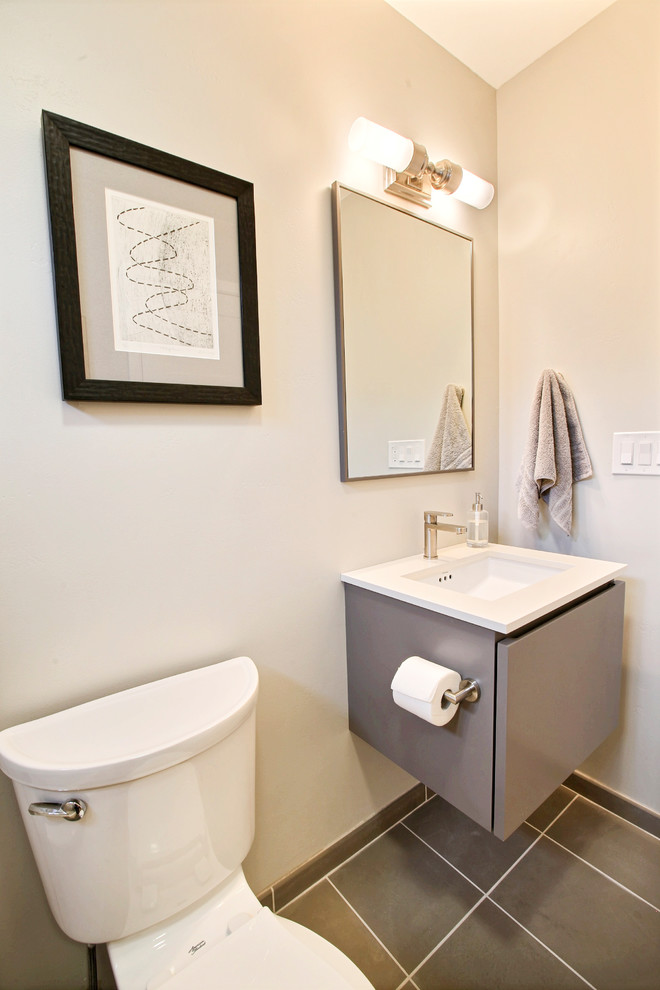 Small modern powder room in Other with flat-panel cabinets, grey cabinets, ceramic tile, white walls, ceramic floors, an integrated sink, solid surface benchtops and grey floor.