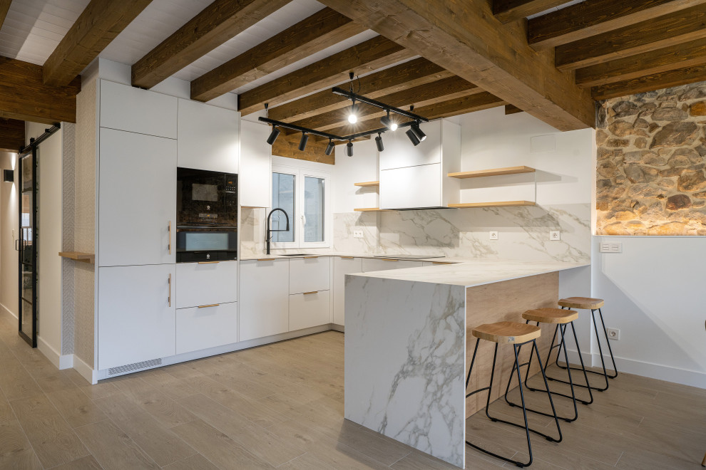 Inspiration for a scandinavian u-shaped exposed beam open concept kitchen remodel in Bilbao with quartz countertops, white backsplash, quartz backsplash, black appliances and white countertops