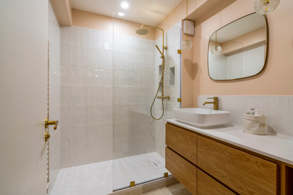 Foto på ett mellanstort funkis vit en-suite badrum, med skåp i mörkt trä, en kantlös dusch, vit kakel, keramikplattor, rosa väggar, terrazzogolv, ett avlångt handfat, bänkskiva i kalksten och vitt golv