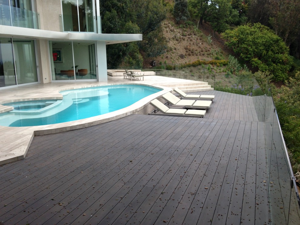 Photo of a large contemporary backyard custom-shaped lap pool in Los Angeles with a hot tub and decking.