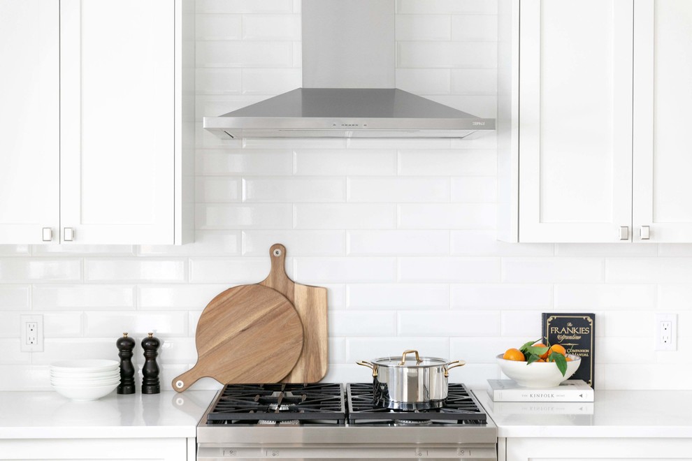 Inspiration for a large transitional u-shaped medium tone wood floor and brown floor eat-in kitchen remodel in Calgary with an undermount sink, shaker cabinets, white cabinets, quartzite countertops, white backsplash, subway tile backsplash, stainless steel appliances, an island and white countertops