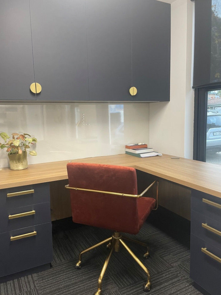 Ejemplo de despacho contemporáneo de tamaño medio con paredes blancas, moqueta, escritorio empotrado y suelo gris
