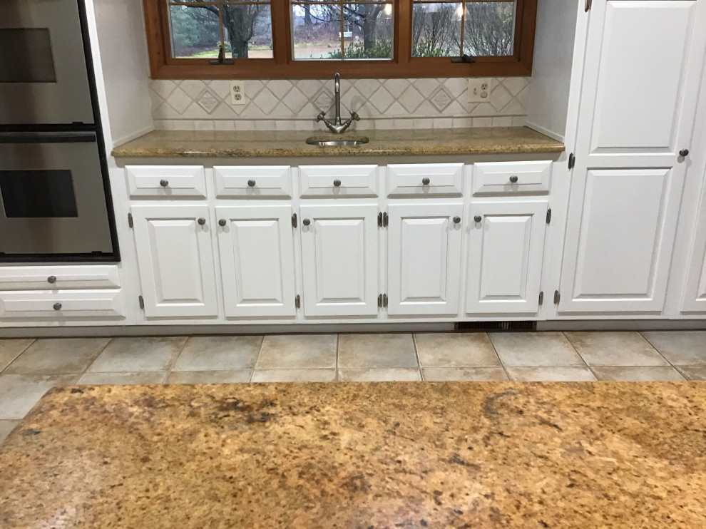 Country kitchen in New York with raised-panel cabinets and with island.