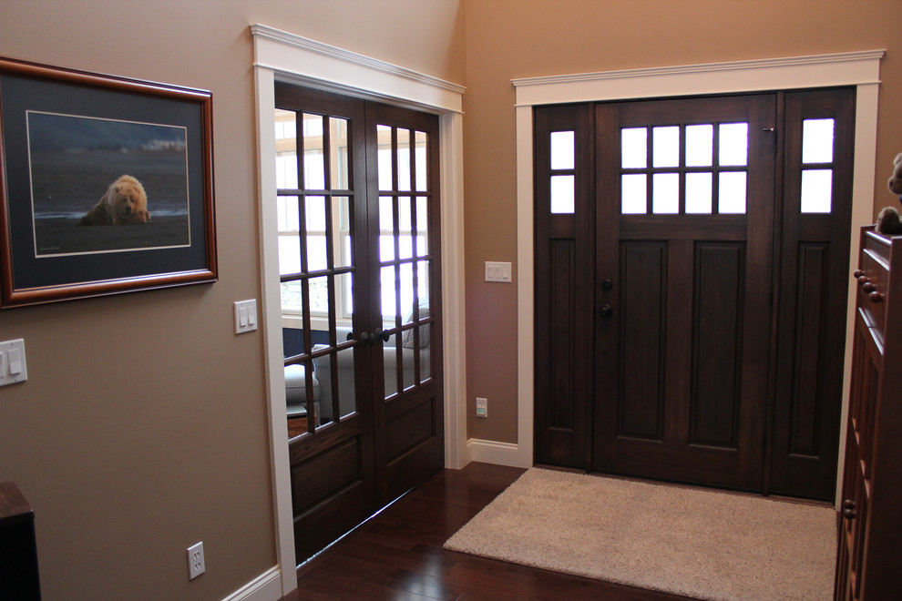 Mid-sized arts and crafts foyer in Other with brown walls, dark hardwood floors, a single front door and a dark wood front door.