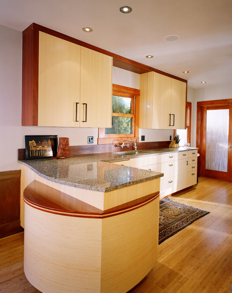 This is an example of a mid-sized modern galley eat-in kitchen in San Francisco with flat-panel cabinets, light wood cabinets, recycled glass benchtops, grey splashback, stainless steel appliances, bamboo floors and an undermount sink.