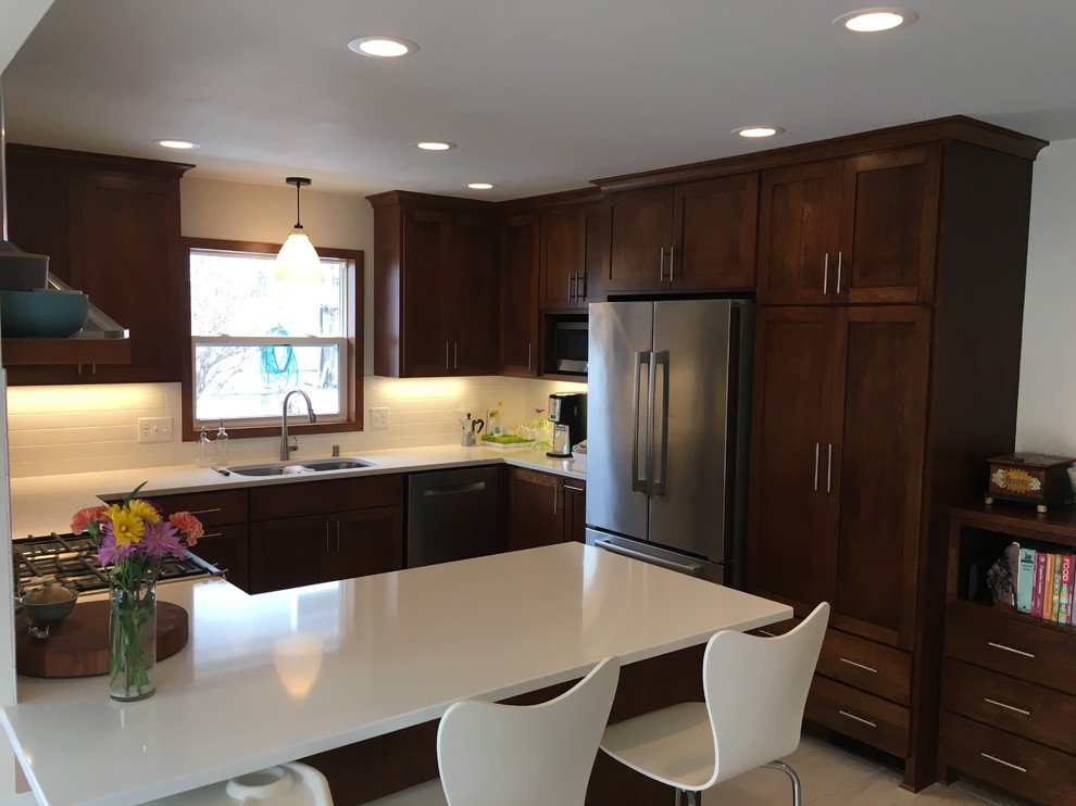 Example of a mid-sized transitional u-shaped porcelain tile and white floor open concept kitchen design with a double-bowl sink, shaker cabinets, dark wood cabinets, quartz countertops, white backsplash, ceramic backsplash, stainless steel appliances and a peninsula